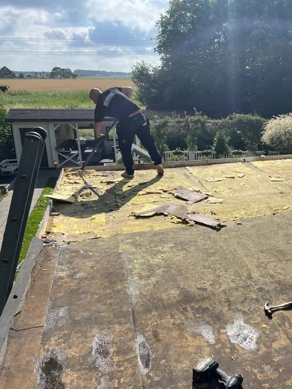 Dakdekker aan het werk bij het verwijderen van de oude dakbedekking