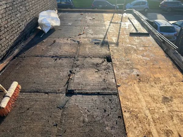 Vóór het werk: kaal plat dak met oude resten dakbedekking en houten beschot