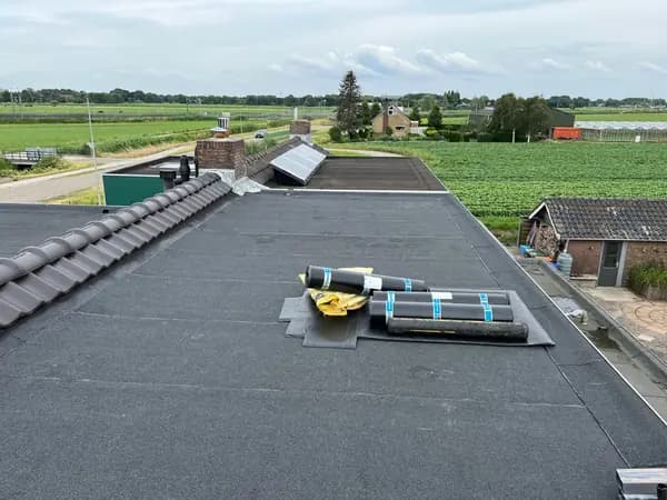 Na het werk: groot plat dak met nieuwe dakbedekking en uitzicht over de polder